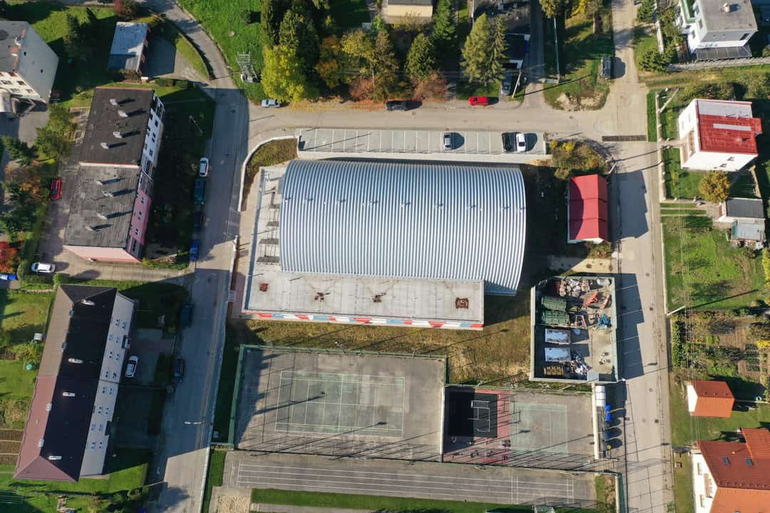 Letecký vertikální pohled shora na obloukovou montovanou ocelovou sportovní halu v Horní Srní postavenou systémem HUPRO SYSTEMS SE