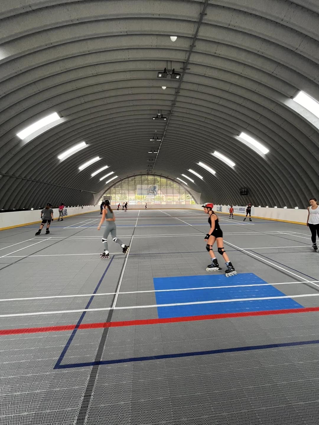 Dívky na kolečkových bruslích v multifunkční montované hale v Hriňové od společnosti HUPRO SYSTEMS SE, s plastovým sportovním povrchem využitelným po celý rok.