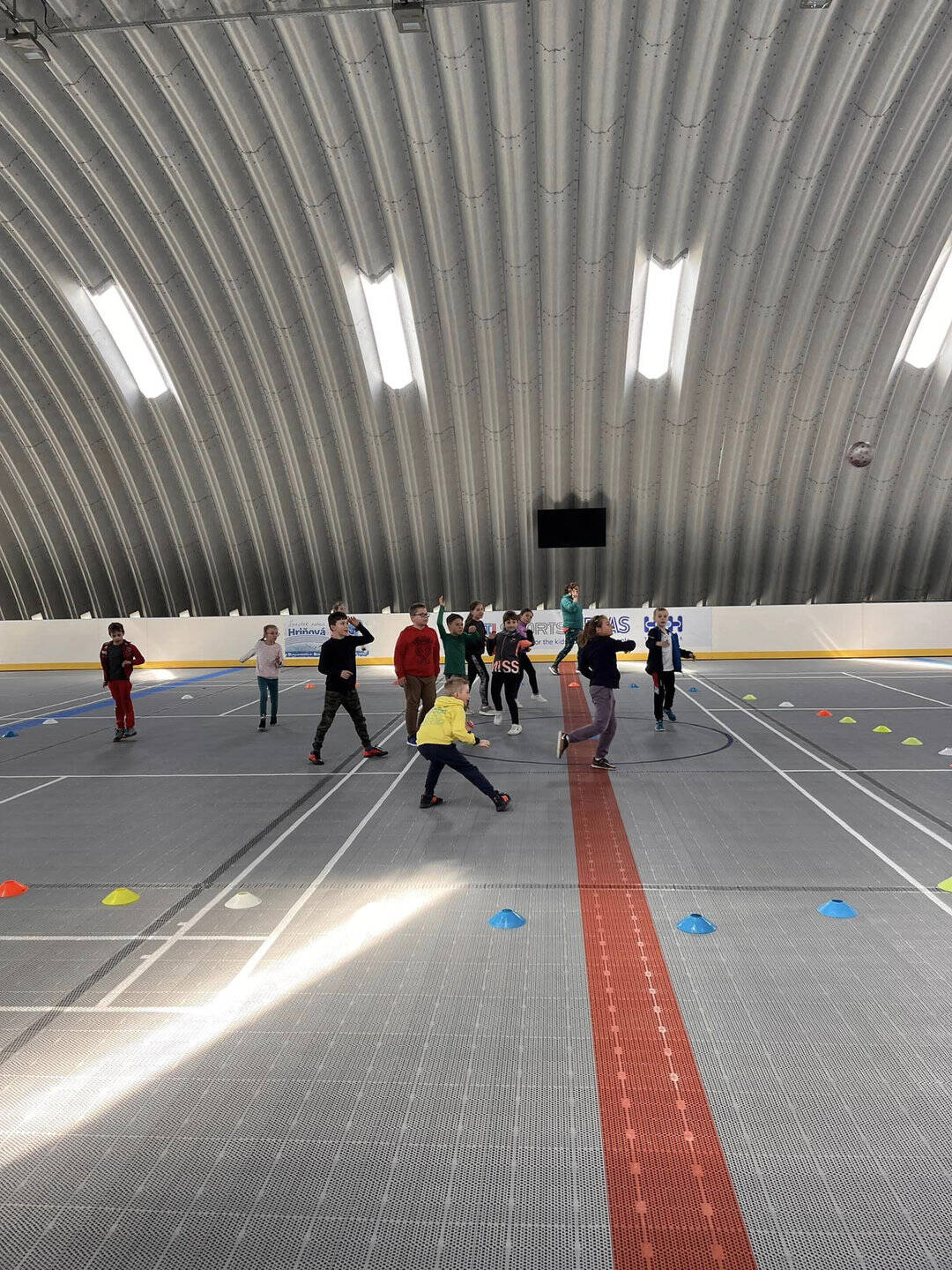 Děti při sportovních aktivitách v multifunkční montované hale v Hriňové, kterou postavila společnost HUPRO SYSTEMS SE, s plastovým povrchem vhodným pro různé sporty.