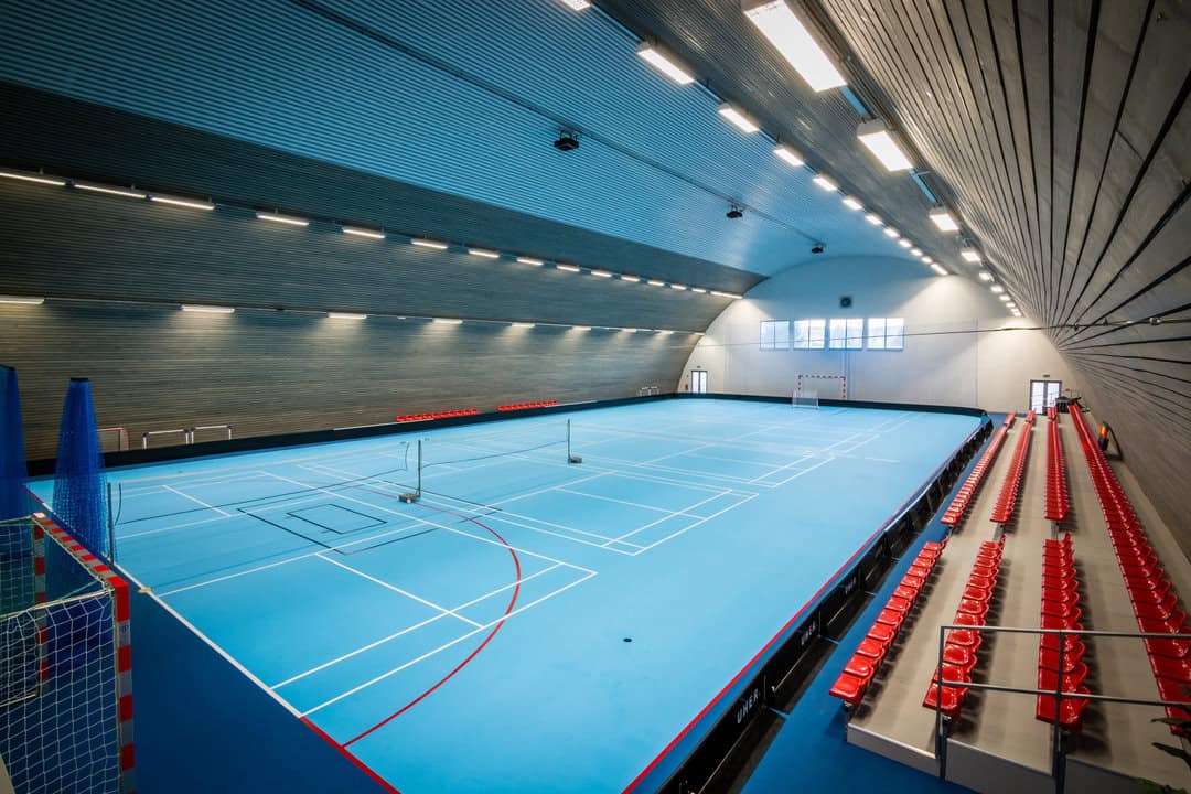 Interiér sportovní haly v Kežmarku s modrým hřištěm a tribunami, postavené systémem HUPRO SYSTEMS SE