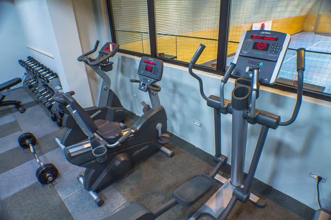 Montovaná ocelová oblouková sportovní hala Kotor – moderní fitness zóna s trenažéry a výhledem do hlavní sportovní haly, realizace HUPRO SYSTEMS SE.