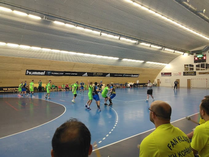 Zápas házené ve víceúčelové sportovní hale v Brně-Maloměřicích s modrým povrchem a dřevěnými stěnami, realizace HUPRO SYSTEMS SE.