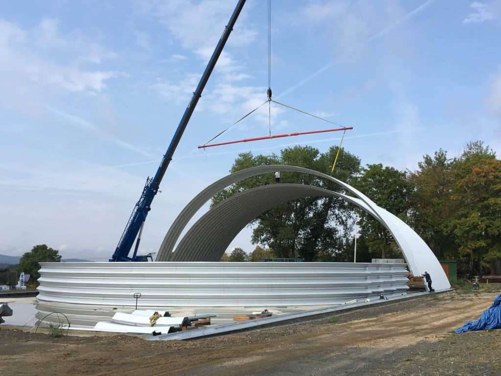 Kynžvart – montáž ocelové obloukové sportovní haly pomocí jeřábu, moderní ocelová konstrukce ve fázi výstavby, realizace HUPRO SYSTEMS SE.