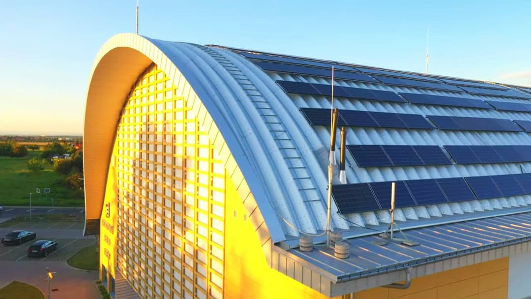 Střecha obloukové montované ocelové sportovní haly Praha Kbely se solárními panely a moderní energeticky úspornou technologií.