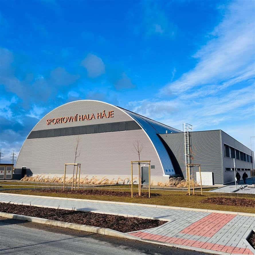 Oblouková montovaná ocelová sportovní hala Háje ve městě Slaný, oceněná jako Stavba roku 2024. Moderní víceúčelový sportovní objekt s elegantní architekturou a kvalitním technickým zpracováním.