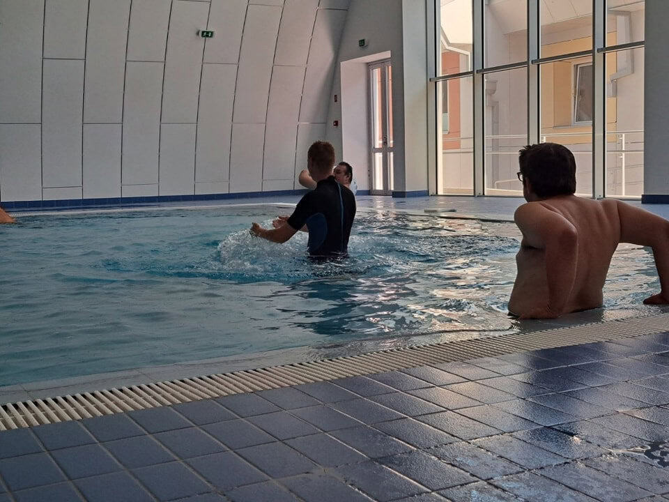 Moderní plavecká hala Subotica, interiér s bazénem a velkými prosklenými okny, výuka plavání pod vedením instruktora, realizace HUPRO SYSTEMS SE.