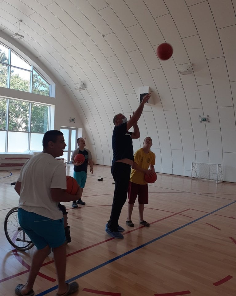 Oblouková sportovní hala Subotica, interiér s dřevěnou podlahou a cvičením basketbalu, skupina hráčů při tréninku, realizace HUPRO SYSTEMS SE.