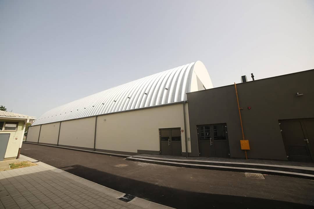 Oblouková sportovní hala Koprivnica, exteriér s moderním opláštěním a napojením na přilehlé budovy, realizace HUPRO SYSTEMS SE.
