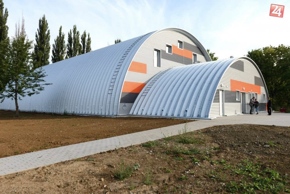 Sportovní hala Nitra Tulipanová – moderní oblouková konstrukce HUPRO SYSTEMS SE s červeno-šedým fasádním obkladem, nově dokončený areál připravený k otevření.