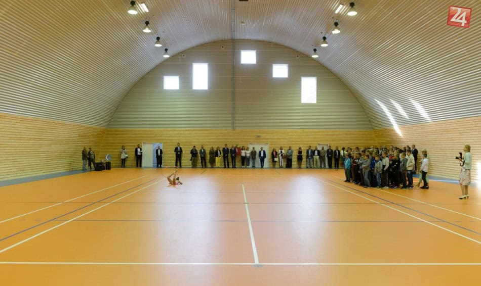 Interiér sportovní haly Nitra Tulipanová při slavnostním otevření – návštěvníci sledují vystoupení gymnastky v nové multifunkční hale od HUPRO SYSTEMS SE.