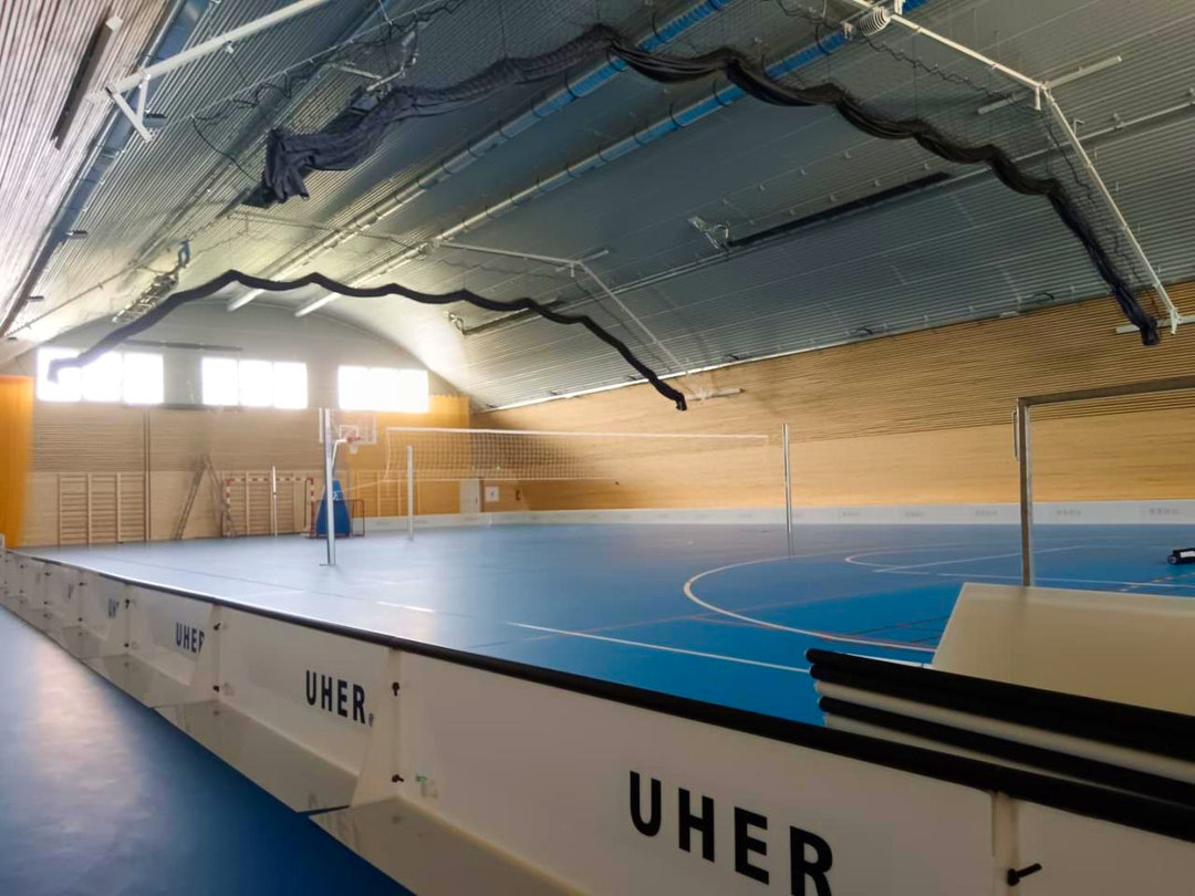 Wnętrze hali sportowej Velké Němčice z siatką do siatkówki i rozsuwaną siatką ochronną. Realizacja firmy HUPRO SYSTEMS SE. Wnętrze hali sportowej Velké Němčice z siatką do siatkówki i rozsuwaną siatką ochronną. Realizacja firmy HUPRO SYSTEMS SE.