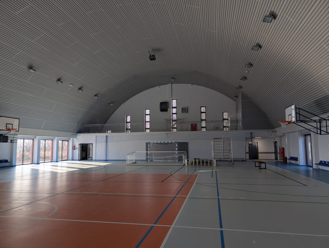 Wnętrze montowanej stalowej łukowej hali sportowej Szaniec z boiskiem wielofunkcyjnym, koszami i bramkami. Realizacja firmy HUPRO SYSTEMS SE. Wnętrze montowanej stalowej łukowej hali sportowej Szaniec z boiskiem wielofunkcyjnym, koszami i bramkami. Realizacja firmy HUPRO SYSTEMS SE.